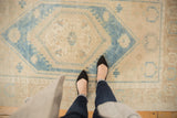 Distressed Oushak rug with soft aqua blue central medallion and low pile texture.