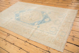 Distressed aqua blue medallion with soothing tones on a neutral Oushak field.