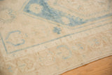 Low pile texture and faded aqua blue curvilinear patterns on distressed vintage Oushak rug.