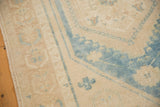Decorative distressed pile of vintage Oushak rug, soft aqua blue and sand tones.