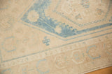 Distressed low pile texture with soothing aqua blue and beige geometric Oushak motifs.