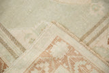 Vintage Oushak rug's secured side edge and low pile, with beige and terra cotta geometric motifs.