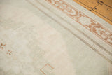 Vintage Distressed Oushak carpet showing terra cotta geometric border on faded beige field.