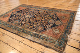 Vintage Malayer rug corner showing intricate floral palmettes in navy, blush copper, and celadon.