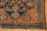 Hand-knotted Malayer rug's lower corner, featuring navy palmettes, blush copper borders, and fringe.