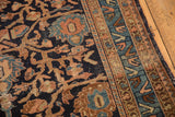 Vintage Malayer rug's side edge, with navy floral vinery, geometric border, and light tatter.