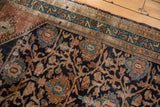 Worn navy field, copper palmettes, and sky blue floral vinery on a vintage Malayer rug.