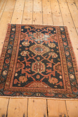 Vintage Lilihan rug detail: navy field with oversized raspberry floral and diamond trellis.