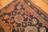Persian Lilihan rug corner with navy field, dusty blush Mina Khani pattern, and visible foundation wear.