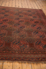 Vintage Ersari carpet showing wine red gul motifs, detailed navy border, and aged fringe.