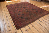 Ersari carpet corner showing wine red and navy gul motifs, secure overcast stitching.