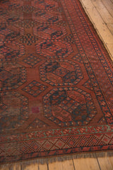 Reddish patch and visible wear within the geometric gul motifs of vintage Ersari rug.
