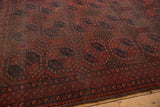 Detailed view of the Ersari carpet's rich wine red and navy gul motifs and patterned border.