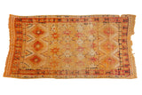 Vintage Moroccan Murat runner with oversized starburst design in saffron yellow and cochineal red.