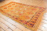Moroccan Murat runner's starburst design with saffron yellow and cochineal red border, tattered end, and edge hole.