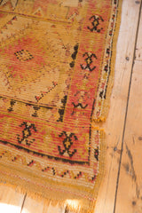 Tattered end of vintage Murat runner, showing worn pile, foundation, saffron yellow, red.
