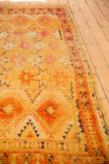 Vintage Murat rug's saffron yellow and tangerine orange field with geometric starbursts and textured wear.