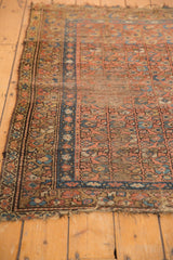 Faded camel and blue borders of a vintage Kurdish Hamadan rug, with tattered fringe and isolated wear.