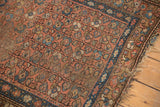 Kurdish Hamadan rug detail: multi-column floral pattern with isolated foundation wear and tattered edge.