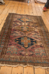 Vintage Malayer rug end with reciprocating pawn border, exposed foundation, and tattered fringe.