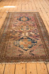 Malayer rug revealing its worn pile, distinct areas of staining, and time-softened colors.