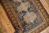 Antique Shirvan rug's geometric borders and distressed indigo field with stylized motifs.