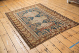 Antique Shirvan rug's worn perimeter, featuring geometric Akstafa border in indigo and rust.