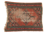 Vintage Hamadan square rug: worn tomato red medallion, navy pawn borders, and tattered ends.