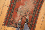 Vintage Hamadan rug with diamond medallion, red field, extensive wear, and pawn borders.