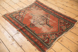 Tomato red vintage Hamadan rug displays wear to foundation, tattered fringe, pawn border.