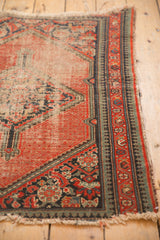 Worn corner of vintage Hamadan rug, showing red pile and reciprocating pawn border.