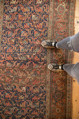 Antique Kurdish Bijar runner showcasing time-softened, interconnected floral motifs in navy and madder red.