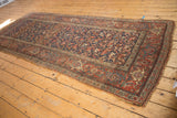 Antique Kurdish Bijar runner corner showing ornate madder red border and worn fringe.