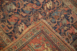 Antique Kurdish Bijar rug's intricate floral border, worn pile, and frayed corner.