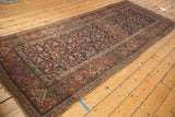 Antique Kurdish Bijar runner's floral pattern in navy, madder red, and green tones, with pile wear.
