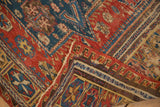 Antique Soumac carpet's reciprocating wave border, cherry red, navy blue, and gold geometric motifs.