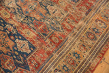 Antique Caucasian Soumac rug section featuring red, navy, and ivory geometric patterns and wave border.
