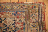Antique Caucasian Soumac rug corner showing geometric border, field motifs, and visible wear.