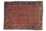 Heriz carpet, brick red geometric floral design with serrated leaves, navy borders.