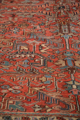 Hand knotted low pile and geometric floral motifs in brick red, navy, and teal hues.