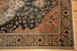 Antique Farahan Sarouk rug's classic border, blush spandrel, and dark blue field with varied pile texture.