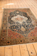 Antique Farahan Sarouk rug's classic border and curvilinear floral field in time-softened blush, navy, ivory.