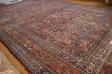 Vintage Meshed rug corner with ornate cochineal red, navy blue, and blush scrolling floral patterns.