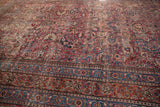 Meshed carpet borders with cochineal red, navy, and burnt orange curvilinear florals.
