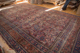 Vintage Meshed rug with intricate curvilinear floral motifs in cochineal red and navy blue.