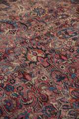 Intricate scrolling curvilinear floral motifs and oversized botehs on the worn vintage Meshed carpet.