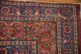 Vintage Meshed rug corner, cochineal red field, blue floral borders, overcast perimeter.
