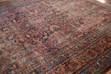 Vintage Meshed rug's ornate borders with cochineal red and navy blue scrolling floral motifs.