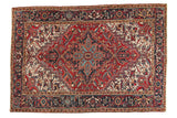 Vintage Heriz carpet with starburst medallion, geometric field, and Samovar border. Cherry red, ivory, navy.