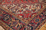 Heriz carpet corner showing cherry red field, serrated leaves, and navy Samovar border.